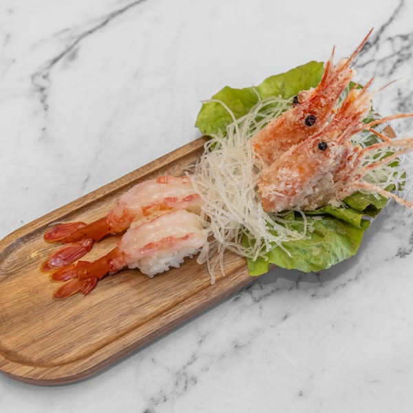 Yashima Restaurant's shrimp nigiri and fried shrimp heads on a wooden tray with lettuce and shredded daikon.