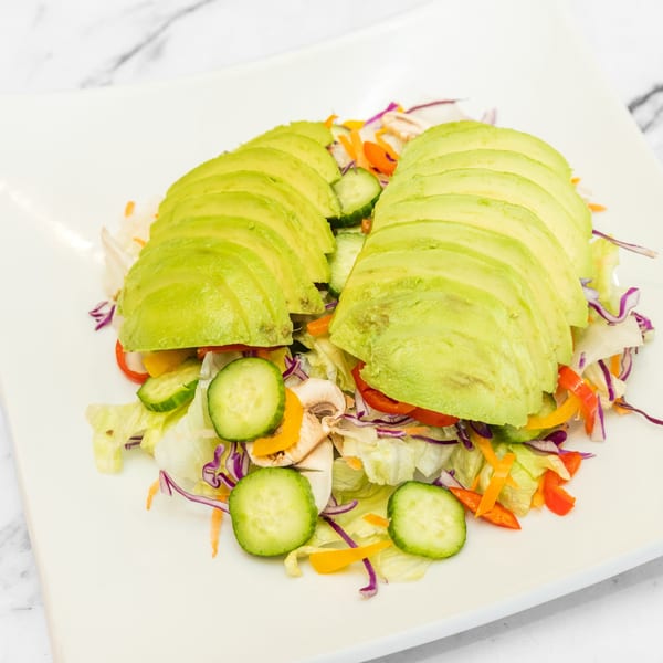Fresh Yashima salad with sliced avocado, lettuce, cucumbers, bell peppers, and red cabbage.
