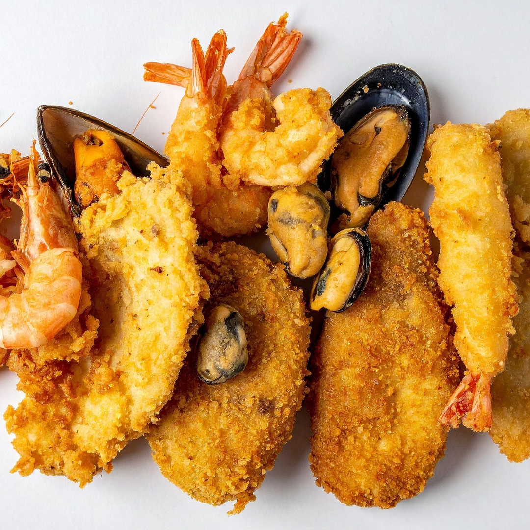 A crispy, golden-brown platter of assorted shrimp and vegetable tempura