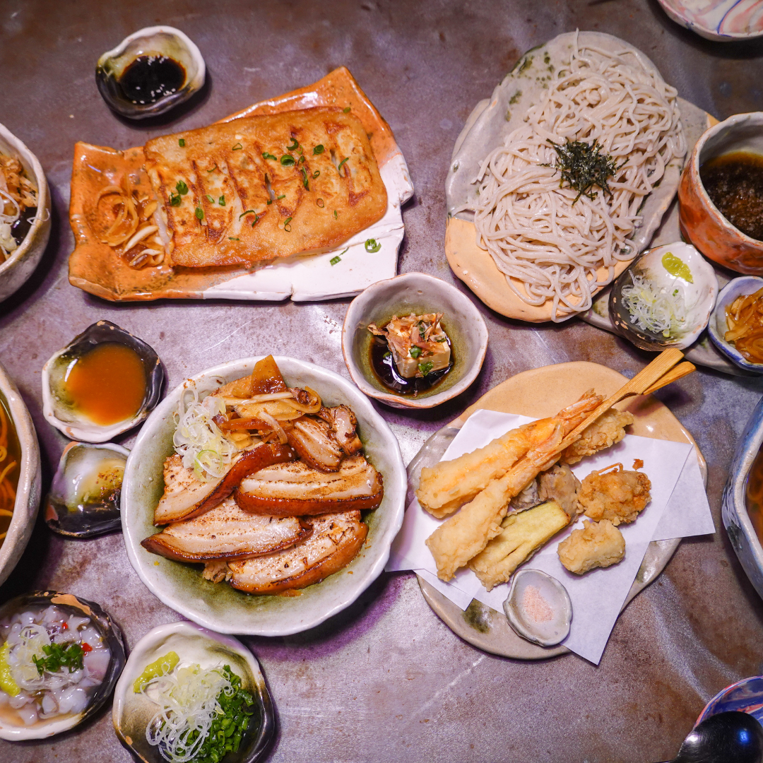 A platter of assorted Japanese appetizers, including tempura and gyoza.