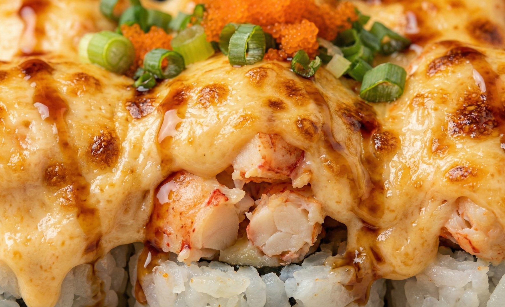 A close-up of the rich, baked topping on a lobster roll.